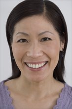 Close up of middle-aged Asian woman smiling