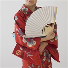 Asian woman in traditional dress holding fan