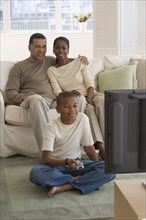 African family watching television in livingroom