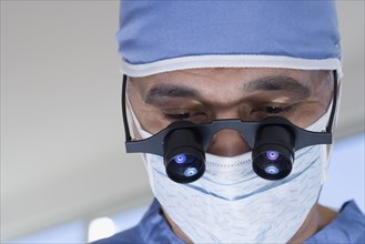 Close up of African male doctor with surgical mask and binocular loupes
