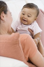 Hispanic baby smiling at mother