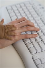Close up of Hispanic mother's and baby's hands on computer keyboard