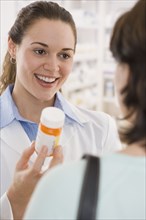 Hispanic female pharmacist giving medication to customer