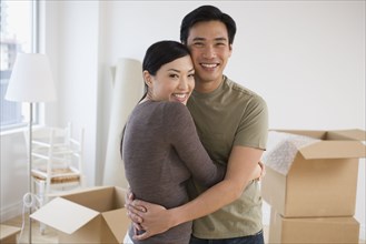 Asian couple hugging in new house