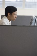 Asian businessman working in cubicle