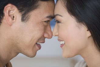 Close up of Asian couple touching foreheads