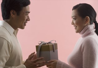 Asian couple exchanging gifts