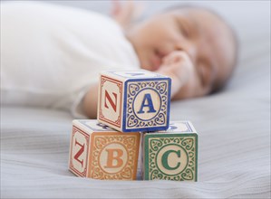 Close up of blocks next to newborn sleeping baby