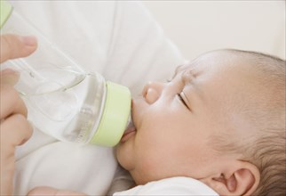 Close up of newborn baby drinking from bottle