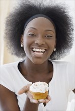 African woman holding cupcake