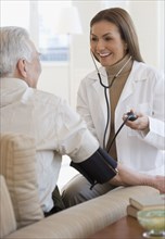 Hispanic female doctor taking patient's blood pressure