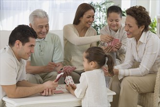 Multi-generational Hispanic family playing cards