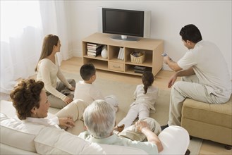 Multi-generational Hispanic family watching television