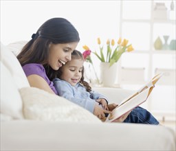 Hispanic mother reading to daughter