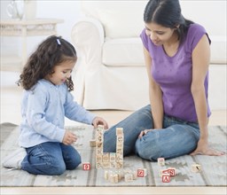 Hispanic mother and daughter playing with blocks