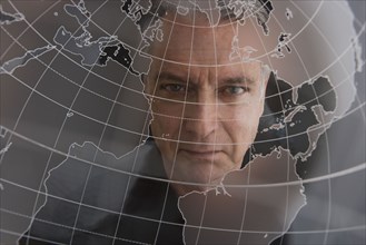 Businessman looking at clear globe