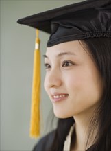 Asian woman wearing graduation cap