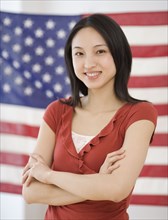 Asian woman standing in front of American flag