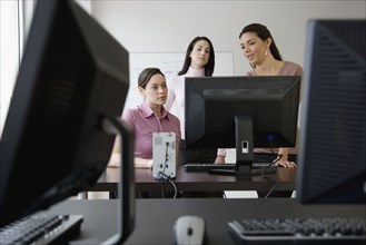 Young businesswomen looking at computer