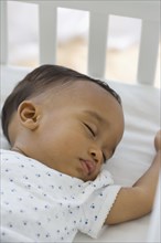 African American baby sleeping in crib