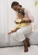African American grandmother drying off baby