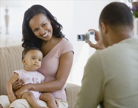 African American father taking photograph of family