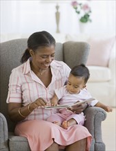 African American grandmother reading to baby