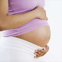 Pregnant African American woman with hands on belly