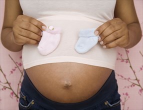 Pregnant African American woman holding booties