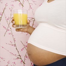 Pregnant African American woman holding orange juice