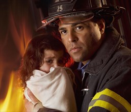 Hispanic male firefighter holding child
