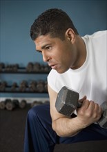 Hispanic man lifting weights
