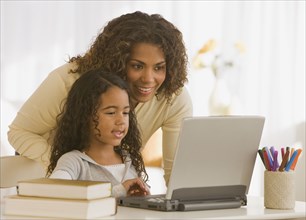 African mother and daughter looking at laptop