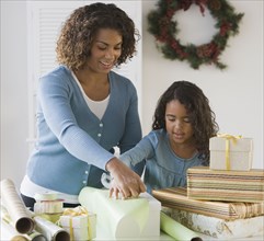 African mother and daughter wrapping gifts