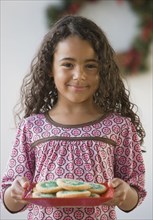 African girl holding plate of cookies
