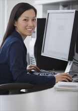 Asian businesswoman sitting at computer