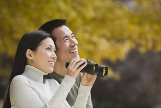 Asian couple holding binoculars
