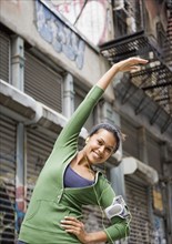 Mixed Race woman stretching in urban area