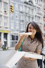 Mixed Race woman eating pizza