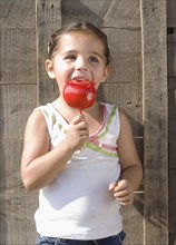 Hispanic girl eating candied apple