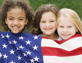 Multi-ethnic girls holding American flag