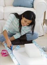 Pacific Islander woman wrapping gift