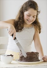 Hispanic girl icing cake