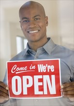 African man holding Open sign