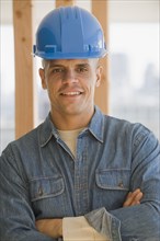 Hispanic male construction worker with arms crossed