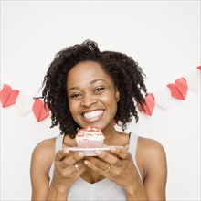 African woman holding cupcake