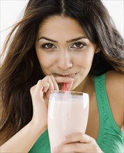 Middle Eastern woman drinking smoothie