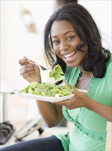 African woman eating salad