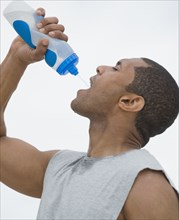 African man drinking from water bottle