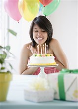Asian woman about to blow out birthday candles